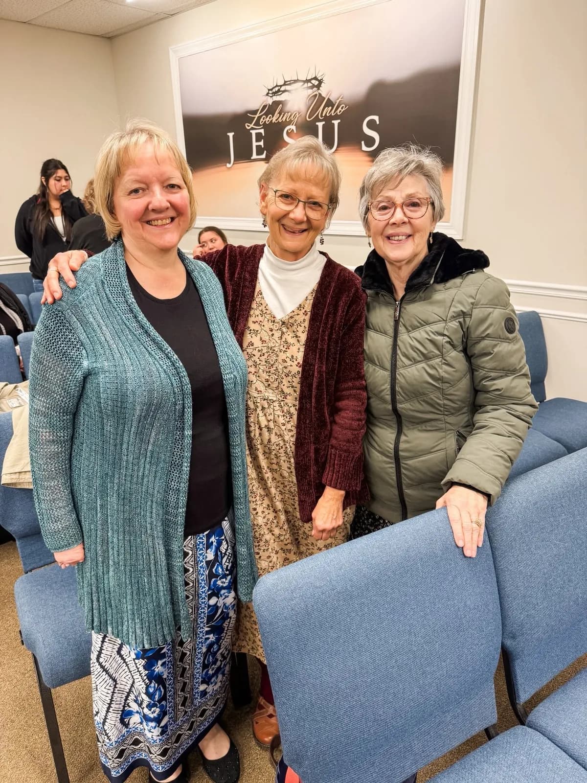Three women smiling together after a service at Grace Baptist Church